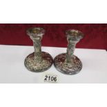 A pair of decorative silver candlesticks, base 8.5cm, 10cm tall.