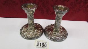 A pair of decorative silver candlesticks, base 8.5cm, 10cm tall.