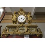 A gilded mantel clock surmounted figures.