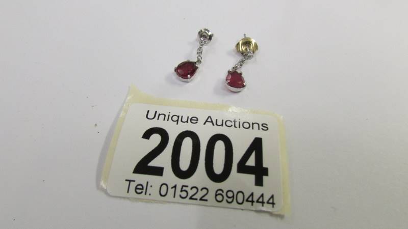 A pair of 14ct white gold and ruby earrings.