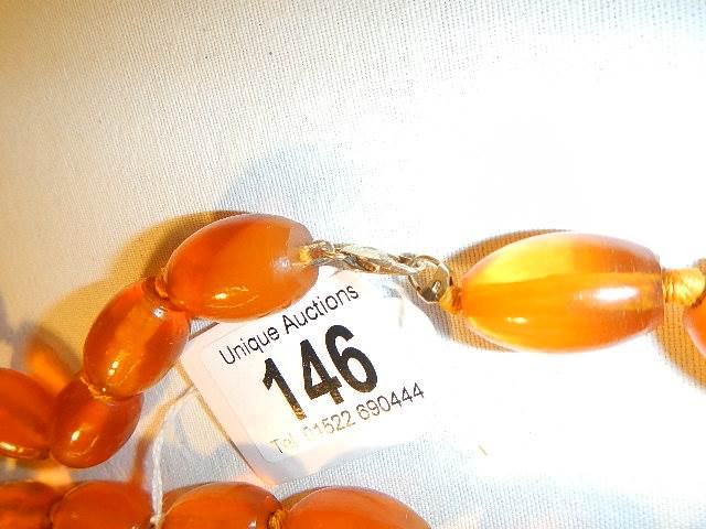 An amber necklace with 9ct gold clasp (approximately 50cm long) and and amber and enamel pendant in - Image 3 of 4