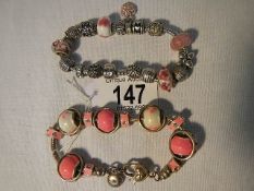 A Pandora stamped bracelet in pink with a similar silver coloured bracelet,