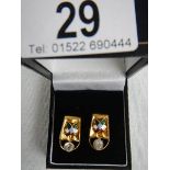 A pair of diamond and enamel earrings, test as 22 ct gold, in good condition.