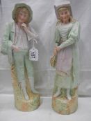 A pair of early 20th century bisque porcelain figures, 38 cm tall.