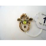 An ealry 20th century peridot and pearl brooch/pendant in gold.