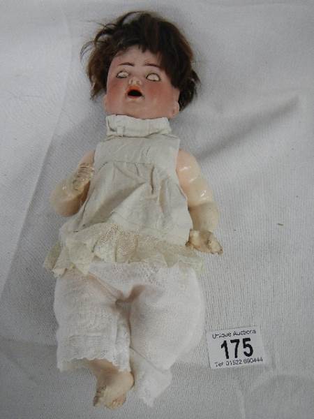 A small early 20th century German bisque headed doll by Kammer and Reinhardt with moveable arms,