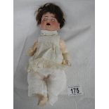 A small early 20th century German bisque headed doll by Kammer and Reinhardt with moveable arms,