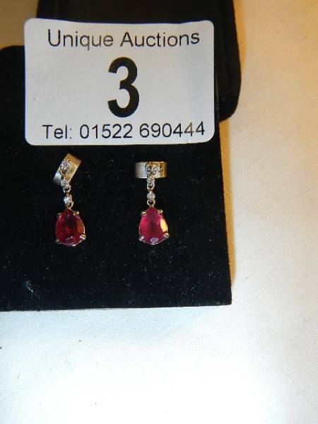 A pair of 14ct white gold earrings set with pear shaped rubies. - Image 2 of 5