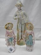 A pair of bisque porcelain figures of a boy and girl (19cm) and another bisque porcelain figure (33