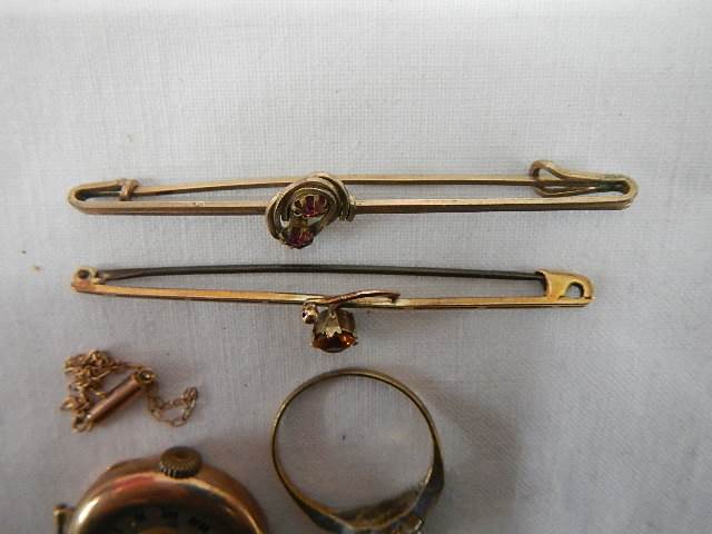 A 9ct gold ring size R Half, A gold ladies watch head, a small chain a/f and two brooches. - Image 3 of 5