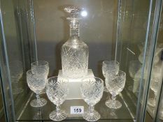 A cut glass decanter with six glasses.