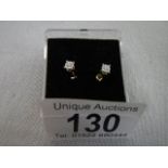 A pair of yellow gold ear studs with white stones.