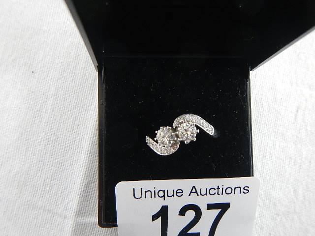 An 18ct white gold crossover diamond ring of 80pts, weight 4.4 grams, size N.