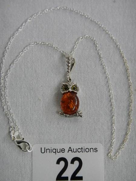 A silver owl set with amber coloured stone on a silver chain, marked 925.