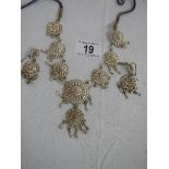 A white metal necklace and earrings, complete and in good condition.