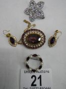 Three good quality brooches and a pair of earrings set with assorted coloured stones.