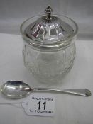 A silver top cut glass preserve pot with silver spoon.