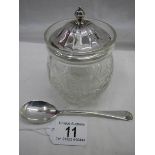 A silver top cut glass preserve pot with silver spoon.