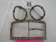 A pair of vintage shoe buckles and a larger buckle.