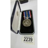 A boxed National Service medal.