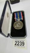 A boxed National Service medal.