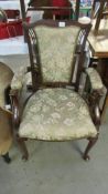 A Victorian elbow chair with floral upholstery.