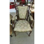 A Victorian elbow chair with floral upholstery.