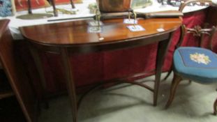 A modern mahogany demi lune hall table.