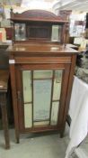 A mahogany cabinet with bevelled glass lettered door 'Cage Bros. Chicago'.