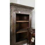 An antique carved oak corner cabinet (missing glass from door).