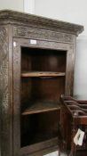 An antique carved oak corner cabinet (missing glass from door).