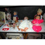 A shelf of vintage dolls including Steiff hedgehog,