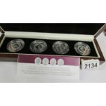 A cased set of four 60th anniversary of the coronation of Queen Elizabeth II silver coins featuring