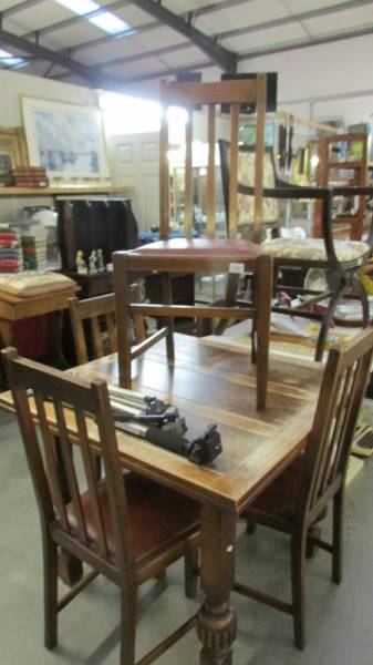 A 1930's oak draw leaf table and 4 chairs.