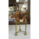 A Victorian copper kettle on a brass trivet.