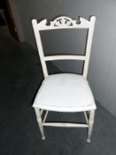 A vintage white painted kitchen chair