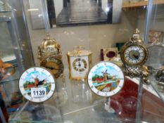 Two small mantel clocks depicting windmills, a battery lantern clock and a battery carriage clock.