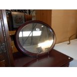 A modern oval mahogany framed mirror, size 50cm x 43cm approx.