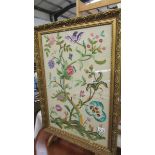 A gilt framed tapestry mounted on legs as a fire screen.