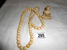 A vintage bone necklace and resin buddah