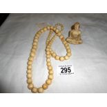 A vintage bone necklace and resin buddah