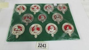 A board of 11 replica clan badges (no backings).