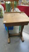 A vintage oak school desk with lift up top and inkwell aperture.