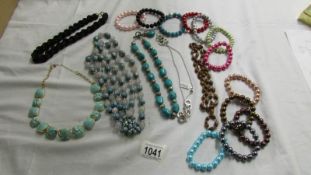 A black rope necklace, 5 other necklace and a quantity of coloured bracelets.