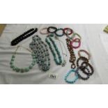 A black rope necklace, 5 other necklace and a quantity of coloured bracelets.