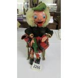 A vintage Scotsman puppet (no strings) sitting on a brass rocking chair.