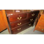 A 2 over 2 mahogany chest of drawers with brass handles.