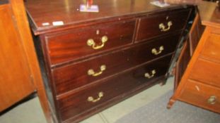 A 2 over 2 mahogany chest of drawers with brass handles.