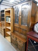 A dark oak drinks cabinet dresser with leaded glass doors and carved drape panels, Height 195cm,