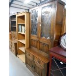 A dark oak drinks cabinet dresser with leaded glass doors and carved drape panels, Height 195cm,